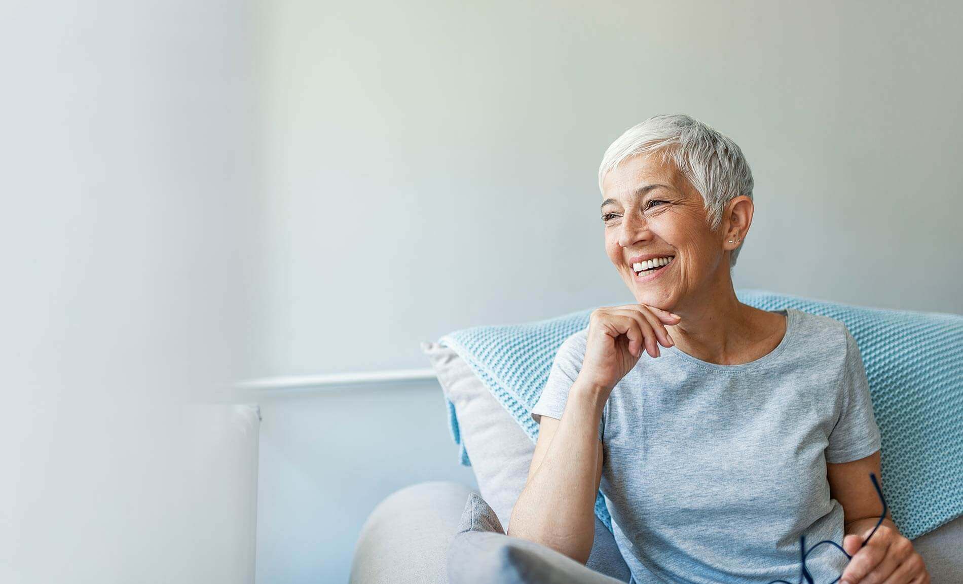 Smiling older woman sitting in.a chair